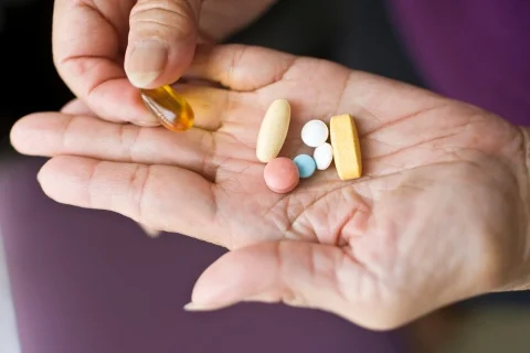 A hand holding a large selection of tablets