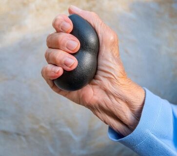 Person grip squishing a medicine stress ball with their hand