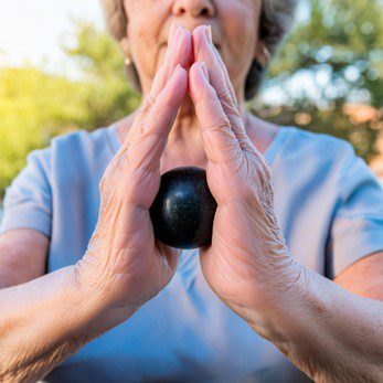 Person holding a small medicine stress bacll between their hands