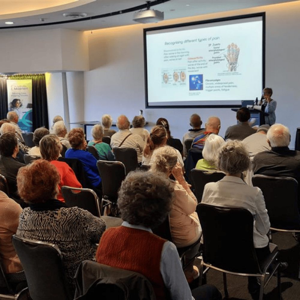 Community Wellness Seminar in progress, people watching presentation